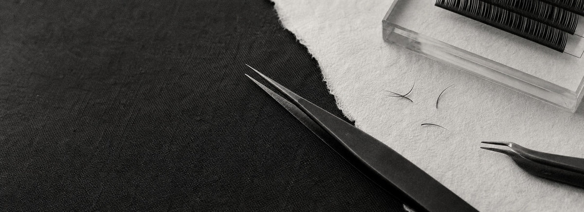 COMELYLASH precision lash tweezers on black fabric